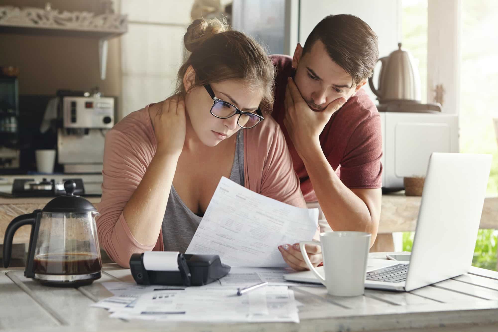 Young Caucasian family having debt problems, not able to pay out their loan. Female in glasses and b