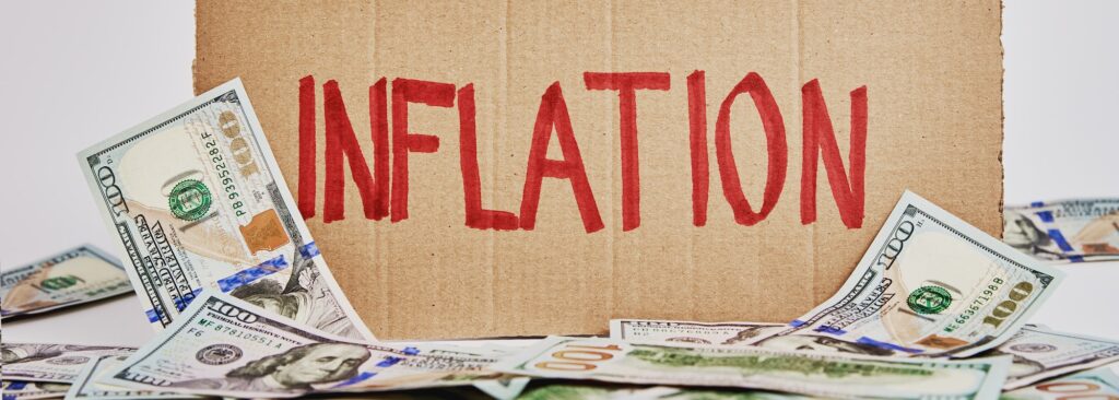 World inflation concept. Cardboard with word inflation and usd banknotes